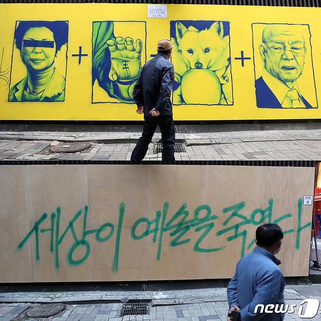 17일 오후 서울 종로구에 위치한 한 중고서점 외벽에 그려져있던 윤석열 국민의힘 대선 후보와 관련된 벽화가 판자로 가려져있다. 가려진 판자 위에 '세상이 예술을 죽였다'라는 문구가 써 있다(아래 사진). 위 사진은 지난14일 가려지기 전 외벽에 그려진 '손바닥 왕', '개 사과', '전두환 옹호' 논란의 키워드 벽화. 2021.11.17/뉴스1 © News1 조태형,박세연 기자