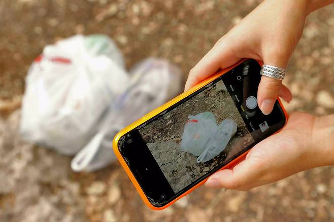 여성은 자신이 모은 쓰레기를 인근 쓰레기통에 버릴 때마다 앱을 실행해 인증 사진을 찍어 올린다.