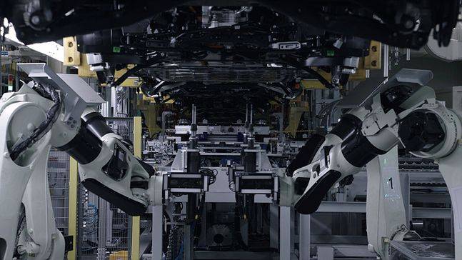 EV6 조립 공정에서 차체와 배터리 모듈이 조립되고 있다. 로봇팔이 비전 시스템으로 볼트를 장착할 위치를 확인하고 정확한 위치에 볼트를 장착해 배터리 모듈을 고정한다. ⓒ기아