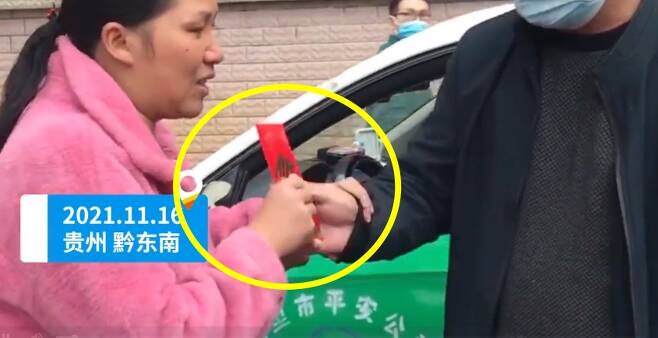 중국 현지시간으로 16일, 목숨을 잃을 뻔한 자녀를 살려준 택시 기사에게 택시비를 전하려는 여성(왼쪽)과 한사코 이를 거부하는 택시 기사(오른쪽)