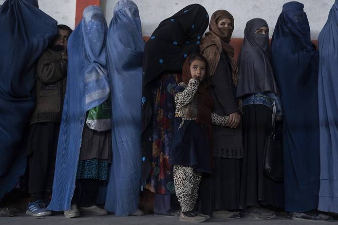 위태로운 눈빛들 세계 아동의날인 20일(현지시간) 아프가니스탄 카불에서 부르카를 입은 여성과 아이들이 유엔 세계식량기구가 지원하는 현금을 받기 위해 길게 줄을 서 있다. 유엔은 아프간 인구의 절반 이상이 식량난으로 고통받고 있으며, 겨울이 다가오면서 상황이 더 악화될 것이라 우려하고 있다.    카불 | AP연합뉴스