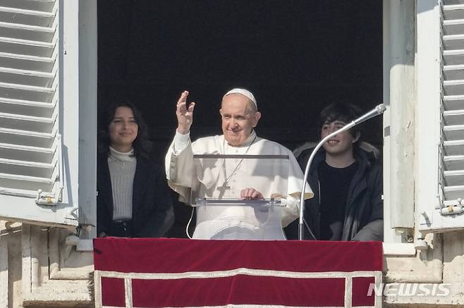 [바티칸시티=AP/뉴시스]프란치스코 교황이 21일 세계 청년의 날을 맞아 성 베드로 광장이 내려다보이는 자신의 작업실 창문에 젊은이들과 나란히 서서 안젤로 정오 기도를 낭송하며 축복을 전하고 있다. 교황은 이날 지구 환경을 보호하기 위한 젊은이들의 노력에 찬사를 보내면서 "사회의 비판적인 양심이 돼야 한다"고 촉구했다. 2021.11.21