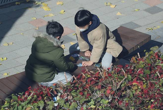 수도권을 포함한 전국 학교가 전면등교를 시작한 22일 낮 서울 마포구 한 초등학교 학생들이 수업을 마친 뒤 친구와 만화 캐릭터 카드 놀이를 하고 있다. 신소영 기자 viator@hani.co.kr