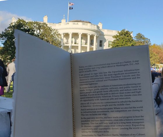 지난 15일(현지시간) 미국 백악관에서 열린 인프라 법안 서명식에서 나눠준 순서지에는 ″기념비적인 한걸음을 내딛게 됐다″는 조 바이든 대통령의 소감이 적혀 있었다. [김필규 특파원]
