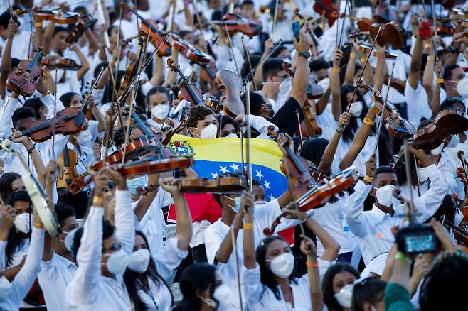 베네수엘라 음악 교육 프로그램 엘시스테마 출신 연주자들이 지난 13일(현지시간) 육군사관학교 광장에 모여 ‘최다 인원 오케스트라 연주’ 기네스북 기록에 도전하고 있다.  카라카스 | 로이터연합뉴스