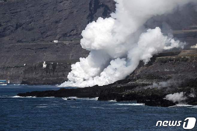 22일(현지시간) 스페인령 카나리아 제도 라팔마섬의 쿰브레 비에하 화산에서 분출된 용암이 대서양 해변으로 흘러들고 있다. © AFP=뉴스1 © News1 우동명 기자