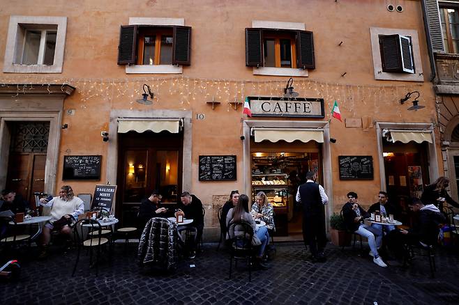 24일(현지 시각) 이탈리아 로마의 한 노상 카페에 사람들이 앉아있다. 이날 이탈리아 정부는 기존 '그린패스'보다 더 엄격한 기준인 '슈퍼 그린패스' 제도를 도입할 계획이라고 밝혔다. /로이터 연합뉴스