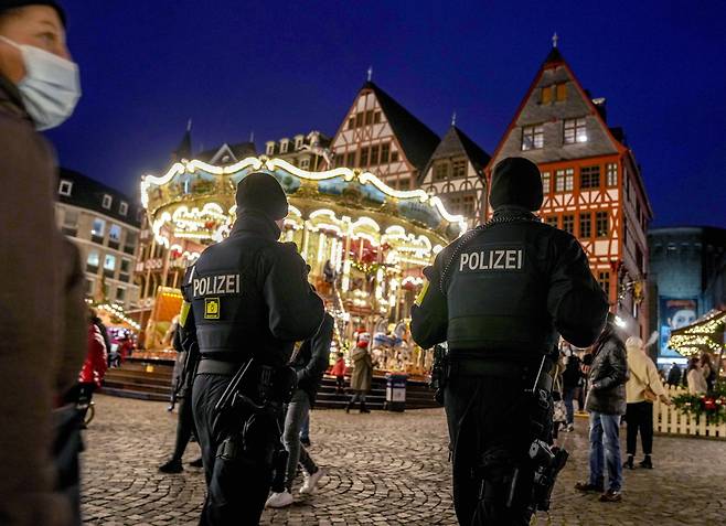 독일 경찰이 23일 밤 프랑크푸르트 도심의 크리스마스 마켓을 순찰하고 있다. 독일에서는 24일 6만8000명의 코로나 신규 확진자가 발생했다. AP=연합뉴스