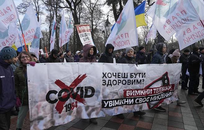 우크라이나 키에프 시민이 24일 코로나 백신 접종 의무화에 반대하는 가두 시위를 벌이고 있다. 플래카드에