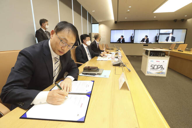 화상으로 진행된 SCFA 총회에 참석한 구현모 KT 대표가 협약서에 서명하고 있다.