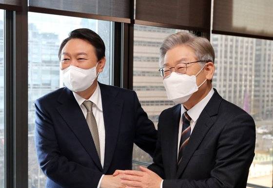 윤석열 국민의힘 대선후보(왼쪽)와 이재명 더불어민주당 대선후보가 24일 2021 중앙포럼에서 만나 악수하고 있다. 김효진 국제퍼스널컬러협회 회장은 “(윤 후보의) 단색 넥타이는 세련되고 고급스러운 느낌을, (이 후보의) 사선 줄무늬 넥타이는 역동적이고 일을 잘한다는 느낌을 준다”고 말했다. 이 후보는 이 행사 다음날 머리를 검게 물들였다. 김경록 기자