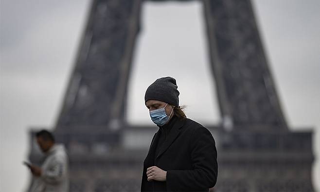 지난 17일(현지시간) 프랑스 파리에서 마스크를 쓴 한 시민이 에펠탑 근처를 걸어가고 있다. EPA연합뉴스