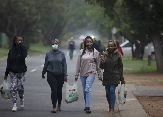 [프리토리아=AP/뉴시스] 27일(현지시간) 남아프리카공화국 가우텡주 프리토리아 거리에서 대학싱들이 장을 본 후 기숙사로 돌아가고 있다. 남아공 과학자들은 남아공 최다 인구 지역인 가우텡의 젊은이들 사이에서 변이 바이러스가 빠르게 퍼져 우려하고 있다고 밝혔다. 남아공의 코로나19 신종 변이 발견으로 많은 국가가 아프리카발 항공편을 막는 등 긴급 봉쇄에 들어가 여행객들의 혼란으로 이어지고 있다. 2021.11.28.