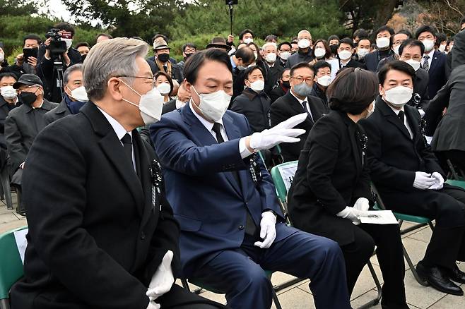 더불어민주당 이재명 대선 후보(왼쪽)와 국민의힘 윤석열 대선 후보(왼쪽두번째)가 22일 오후 국립서울현충원에서 열린 김영삼 전 대통령 서거 6주기 추모식에서 대화하고 있다. /연합뉴스