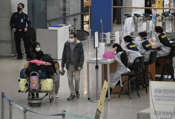 정부가 코로나19 새 변이인 '오미크론'의 국내 유입을 막기 위해 아프리카 8개국에 대한 입국 제한을 28일 실시했다. 이날 인천공항 1터미널에서 해외 입국자들이 방역 요원들 옆을 지나가고 있다. 사진=박범준 기자