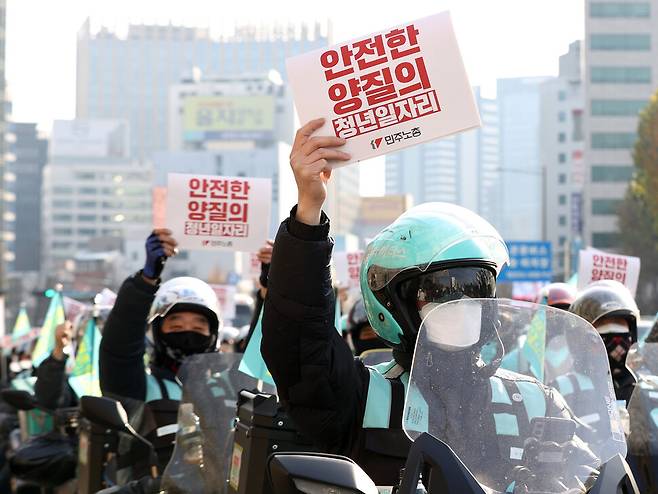 28일 오후 서울광장에서 민주노총 주최로 열린 청년노동자대회를 마친 배달노동자들이 배달오토바이 공제조합 설립 예산 반영과 안전한 양질의 청년일자리 보장 등을 촉구하며 손팻말을 들고 있다. 연합뉴스