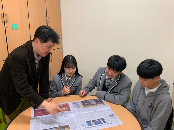 김윤구 하나고등학교 교사가 신문을 활용해 경제를 가르치고 있다.왼쪽부터 김 교사, 2학년생 김영현, 매경 NIE 경진대회 최우수상 수상자 이준구, 우수상 수상자 김선구 학생.