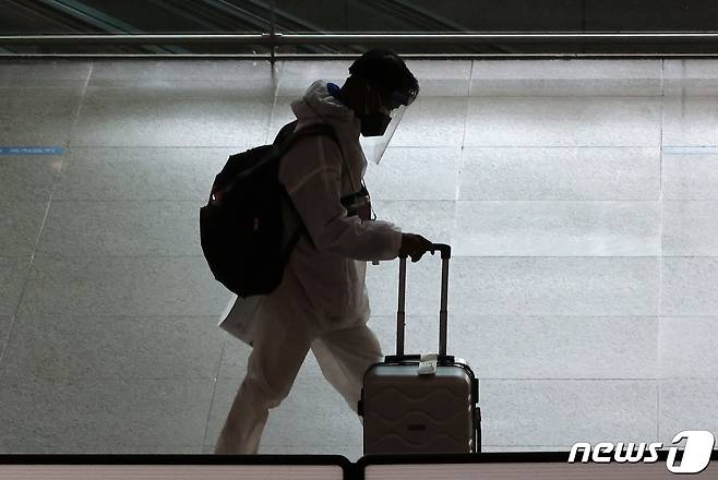 인천국제공항 제1여객터미널에서 방호복과 페이스 쉴드를 착용한 해외 입국자들이 이동하고 있다. 2021.11.29/뉴스1 © News1 조태형 기자