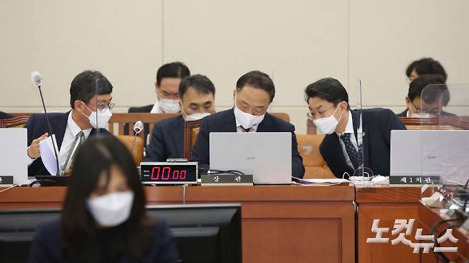 홍남기 경제부총리 겸 기획재정부 장관(가운데)이 30일 국회에서 열린 기획재정위원회 전체회의에서 이억원 기재위 제1차관, 안도걸 제2차관과 함께 자료를 보며 논의하고 있다. 윤창원 기자