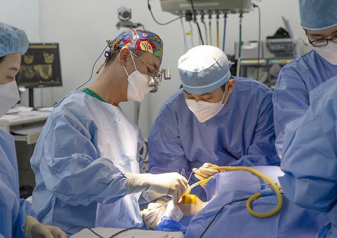 오태석 서울아산병원 성형외과 교수(왼쪽에서 두 번째)가 구순구개열 환아에게 입술 봉합술을 시행하고 있다.