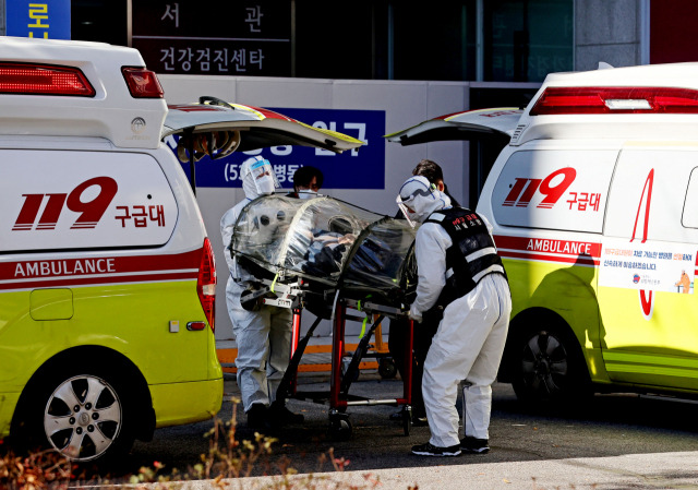 국내 신규 확진자가 5,123명으로 사상 처음으로 5,000명대를 넘어선 1일 119 구급대원 및 의료진이 서울 은평구 서울시립서북병원에서 코로나19 확진 환자를 감염방지용 카트에 실어 병실로 옮기고 있다. /연합뉴스