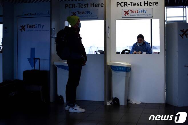 29일(현지시간) 네덜란드 암스테르담 소재 스키폴국제공항에서 마스크를 쓴 한 남성이 신종 코로나바이러스 감염증 유전자증폭(PCR) 진단 검사를 받기 위해 대기하고 있다. 2021.11.29 © AFP=뉴스1