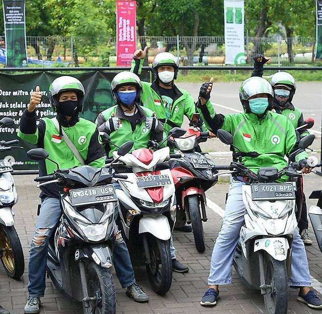 동남아 차량 공유업체 인도네시아 '고젝'의 오토바이 운전 기사들이 서서 포즈를 취하고 있는 모습. /고젝(Gojek)