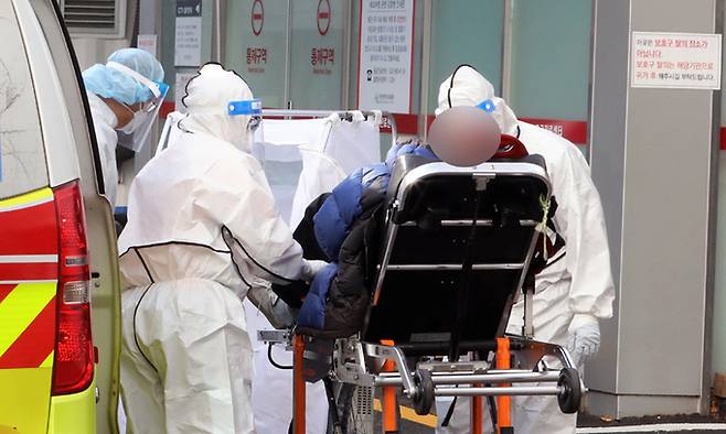 방역당국 관계자들이 2일 오미크론 변이 확진자가 치료 중인 것으로 알려진 인천시의 한 병원 음압치료병상 출입구에서 코로나19 환자를 옮기고 있다. 뉴스1