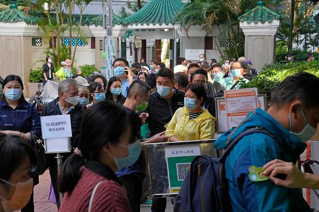 2021년 11월 29일 홍콩의 한 코로나19 백신 접종소에서 시민들이 마스크를 쓰고 줄 서있다. /연합뉴스