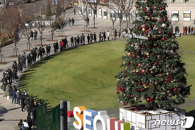 3일 오후 서울시청 앞 광장에 마련된 임시선별진료소를 찾은 시민들이 코로나19 검사를 받기 위해 길게 줄지어 서 있다. .2012.12.3/뉴스1 © News1 이광호 기자