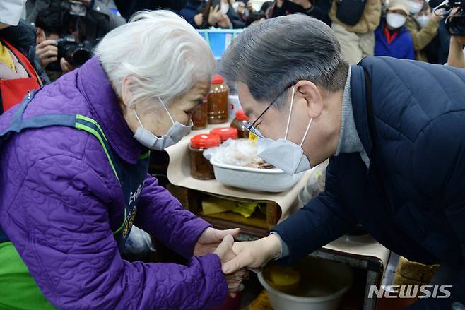 [군산=뉴시스] 김얼 기자 = 이재명 더불어민주당 대선 후보의 매타버스(매주 타는 민생 버스) 전북지역 순회가 이어지고 있는 4일 전북 군산시 군산공설시장을 방문한 이재명 후보가 시장 상인과 인사를 나누고 있다. 2021.12.04. pmkeul@newsis.com