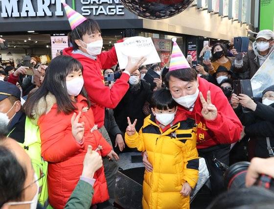 윤석열 국민의힘 대선 후보가 4일 오후 부산 서면 젊음의 거리에서 이준석 대표와 어린이들로부터 생일케이크를 받고 함께 기념 사진을 찍고 있다. 생일 케이크에는 '오늘부터 95일 단디하자'라는 문구가 적혀 있다. 뉴스1