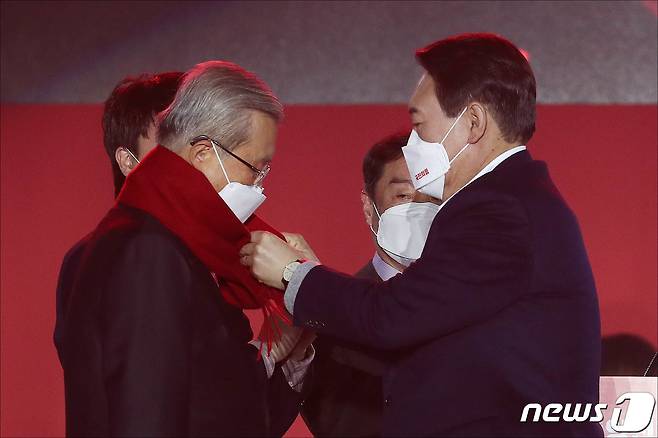 윤석열 국민의힘 대선 후보가 6일 오후 서울 송파구 올림픽공원 체조경기장에서 열린 국민의힘 제20대 대통령선거 선거대책위원회 출범식에서 김종인 총괄선대위원장에게 빨간색 목도리를 둘러주고 있다. 2021.12.6/뉴스1 © News1 구윤성 기자