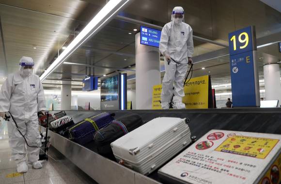 코로나19 오미크론 변이 바이러스 유입으로 방역에 비상이 걸린 인천국제공항 제1터미널 세관구역 수하물 컨베이어 벨트에서 공항 관계자들이 방역을 하고 있다.  [사진=뉴시스]