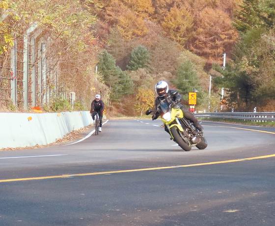 Cyclists and motorcyclists enjoy the sharp twists and turns in Piballyeong, a valley in North Chungcheong's Cheongju. [KIM HONG-JUN]