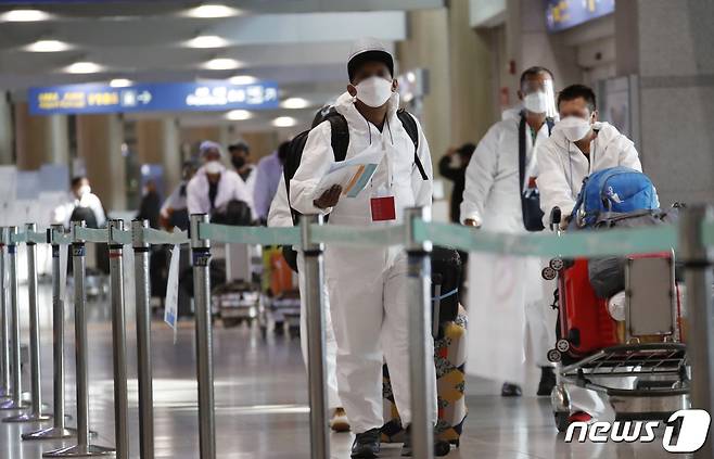 6일 인천국제공항 1터미널에서 해외 입국자들이 임시 생활시설행 특별수송버스를 타기 위해 이동하고 있다. 신종 코로나바이러스 감염증(코로나19) 변이 바이러스인 오미크론의 유입을 막기 위해 지난 3일부터 2주간 해외에서 국내로 들어오는 모든 내·외국인은 백신 접종 여부와 상관없이 10일간 격리하게 된다. 2021.12.6/뉴스1 © News1 권현진 기자