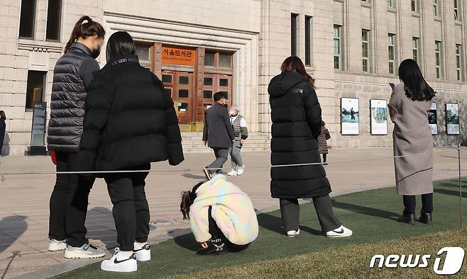 신종 코로나바이러스 감염증(코로나19) 신규 확진자가 7천명을 넘어선 8일 오후 서울광장에 마련된 코로나19 중구 임시선별검사소를 찾은 한 어린이가 대기 시간이 길어지자 힘들어 하고 있다. 2021.12.8/뉴스1 © News1 임세영 기자