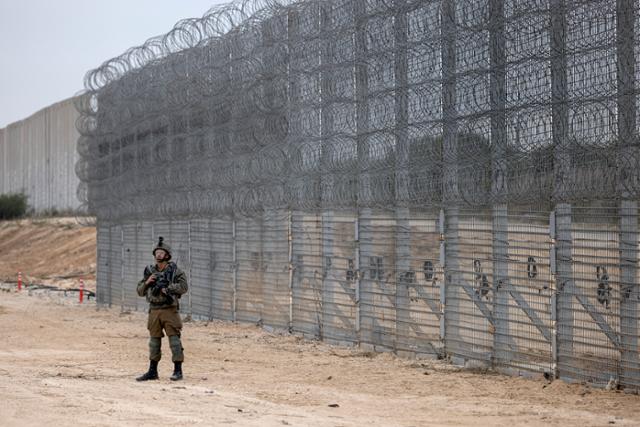 이스라엘과 팔레스타인 가자지구 경계에 설치된 장벽 앞에서 7일 이스라엘 군인이 경계 근무를 서고 있다. 가자=AP 연합뉴스