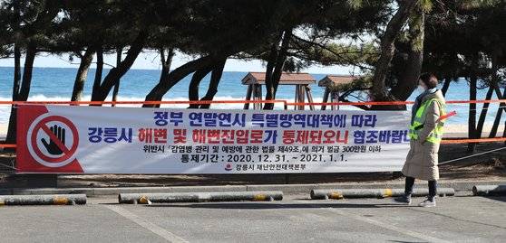 강릉시가 코로나19 확산을 막기 위해 내년 1월 1일 해맞이 축제를 열지 않기로 했다. 사진은 지난해 12월 경포 해변에 건 출입통제 안내 현수막. [뉴스1]