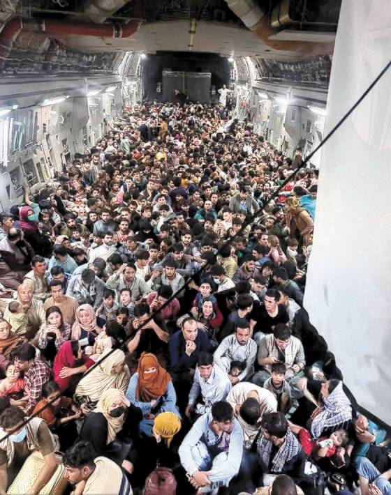 지난 9월 15일 아프가니스탄을 탈출하는 아프간인 640명이 미 공군 C-17 수송기에 발 디딜 틈 없이 앉아 있다. 공식 최대 탑승 인원은 134명이지만 아프간인들이 후방 적재문으로 몸을 밀어 넣어 탑승했다. [로이터=연합뉴스]