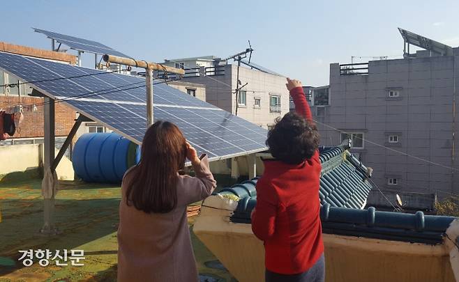 삼호그린빌리지 주민이 8일 주택옥상에서 남구행복에너지센터 관계자와 태양광 모듈 관리방법에 대해 이야기를 나누고 있다. 백승목 기자 