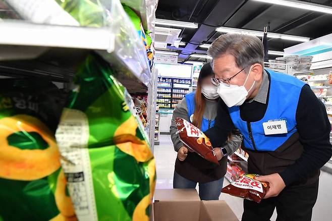 [서울=뉴시스] 국회사진기자단 = 이재명 더불어민주당 대선 후보가 8일 서울 서초구 소재 장애인 직업훈련형 편의점을 찾아 상품을 진열하고 있다. 2021.12.08.