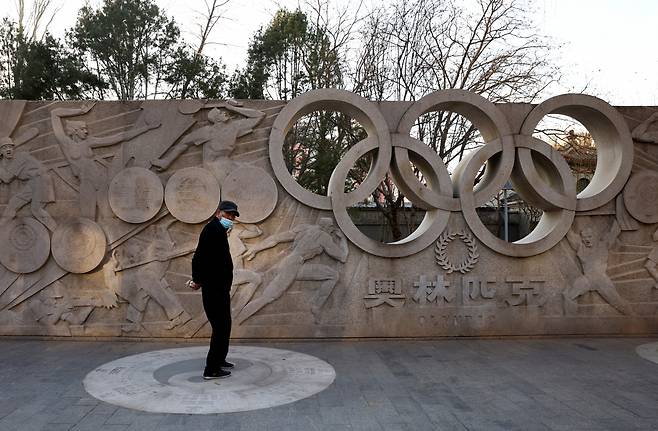 지난 7일(현지시간) 한 중국 시민이 베이징(北京) 시내에 설치된 2022 베이징 동계 올림픽 관련 조형물 앞을 걸어가고 있다. [로이터]