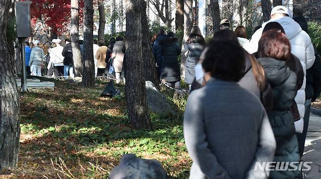 [대구=뉴시스] 이무열 기자 = 코로나19 확진자 수가 7000명대를 넘어선 8일 오전 대구 중구 국채보상운동기념공원 임시선별검사소에서 시민들이 PCR 검사를 받기 위해 순서를 기다리고 있다. 2021.12.08. lmy@newsis.com