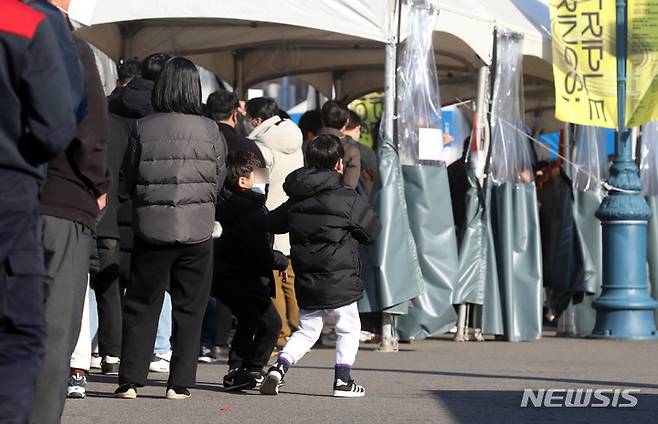 [서울=뉴시스] 고승민 기자 = 코로나19 신규 확진자 수가 사상 처음으로 7,000명을 넘은 8일 서울역 임시선별검사소에서 부모와 함께 온 어린이가 줄을 서고 있다. 위중증 환자 수 역시 최초로 800명 이상 집계되면서 위기감이 고조되고 있다. 질병관리청 중앙방역대책본부(방대본)에 따르면 이날 0시 기준 코로나19 확진자 수는 7,175명 늘어 누적 48만9484명이다. 재원 중인 위중증 환자 수는 840명이다. 종전 최다였던 전날 774명보다 66명 증가했다. 2021.12.08. kkssmm99@newsis.com