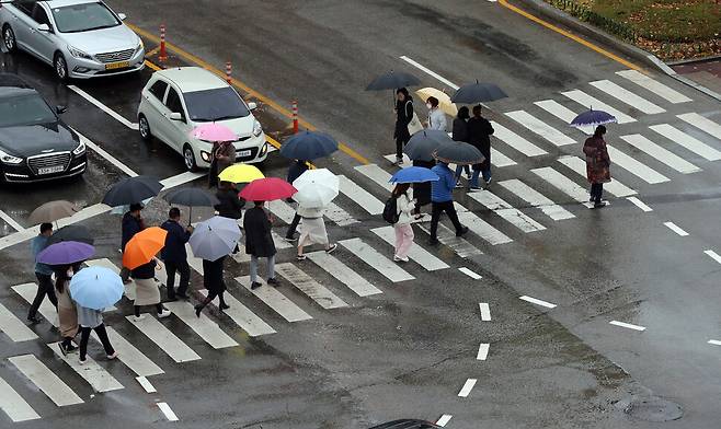 겨울비가 내리는 지난달 30일 오전 광주 북구청 앞 도로에서 우산 쓴 시민들이 길을 건너고 있다. 연합뉴스