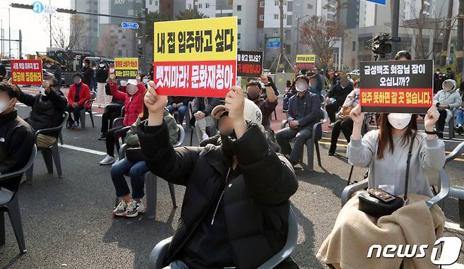 문화재청 명령으로 공사가 중단된 아파트단지 입주예정자들이 지난 11월 14일 오후 인천시 서구 원당동 검단신도시에서 열린 건설사 간담회에서 팻말을 들어보이고 있다. /사진제공=뉴스1