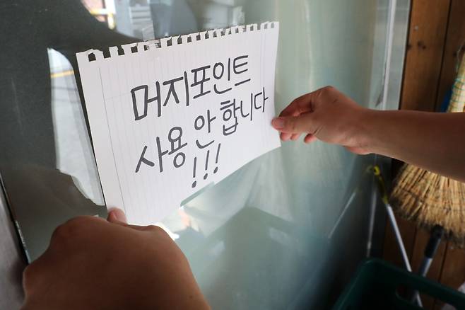 지난 8월19일 오후 서울 시내 한 식당점주가 머지포인트 사용 불가 안내문을 붙이고 있다. /사진제공=뉴시스
