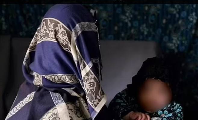 신원이 공개되지 않은 40세 아프간 여성과 자식의 모습