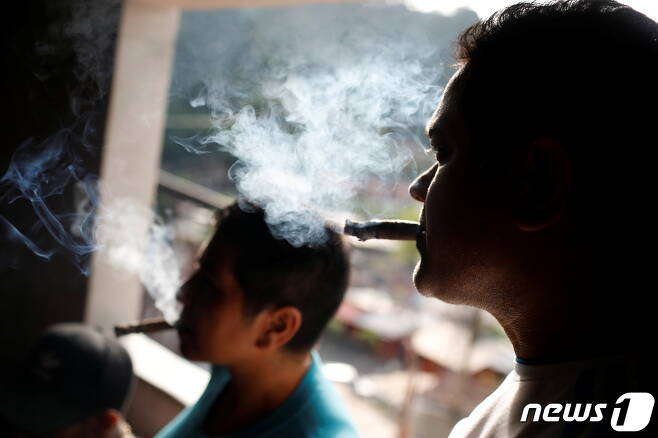 2명의 시민이 담배를 태우고 있다. © 로이터=뉴스1 © News1 김지현 기자